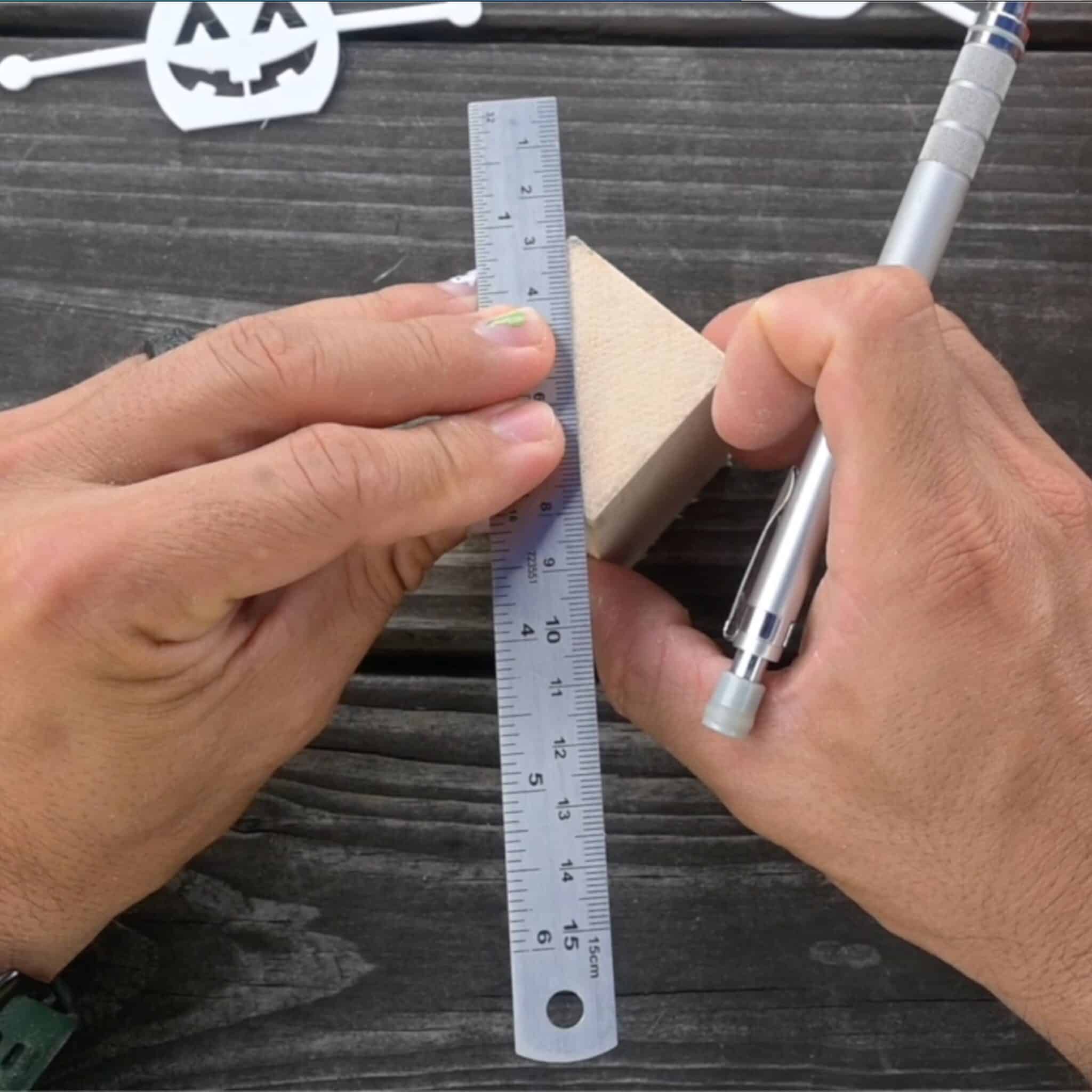 using a small ruler to mark diagonals on a block of wood