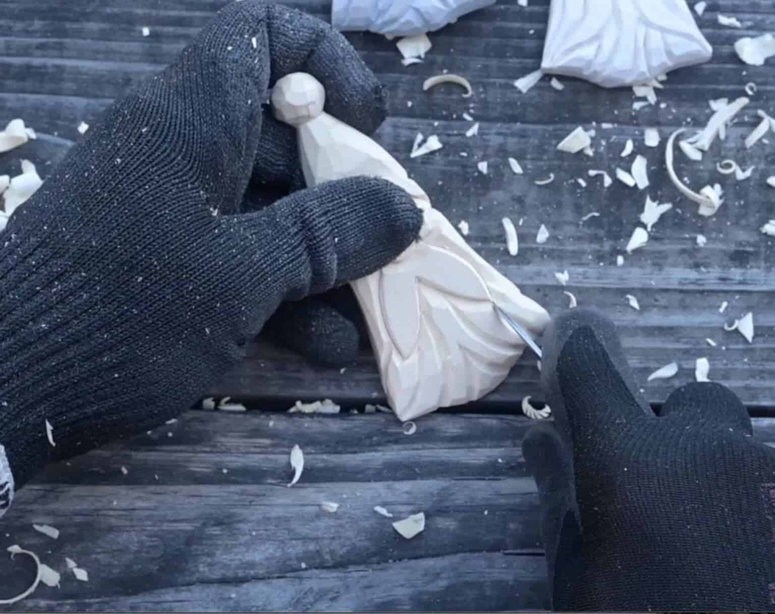 using a knife to carve the beard of a wood santa