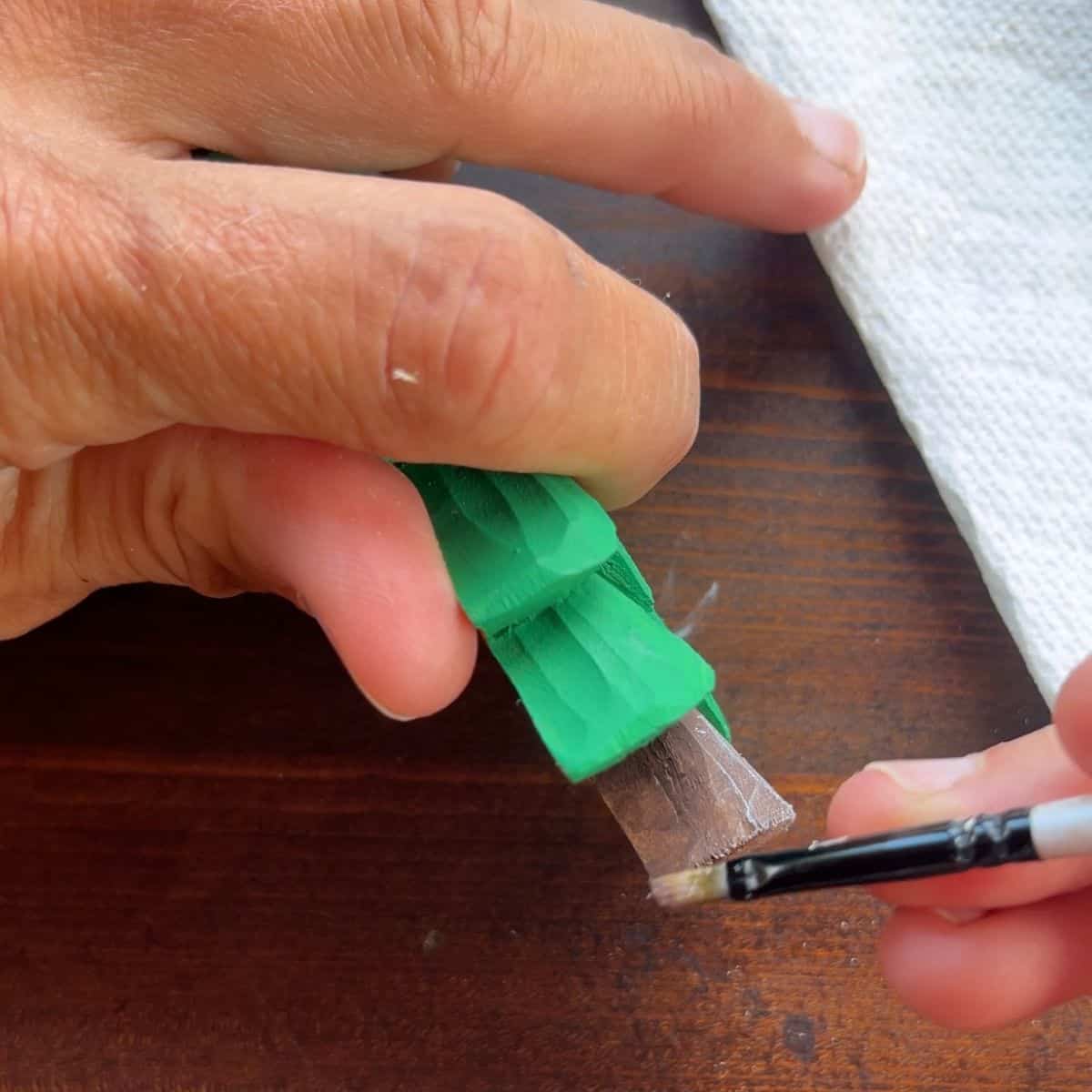 dry brushing the trunk of a wood christmas tree