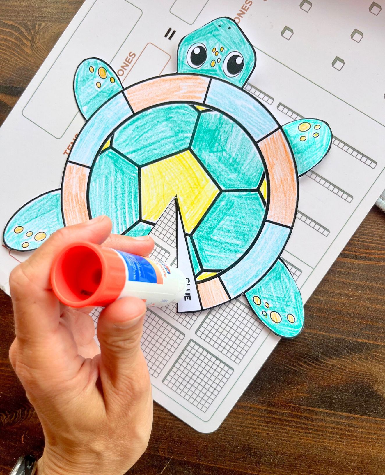 using a glue stick to assemble a printable turtle craft