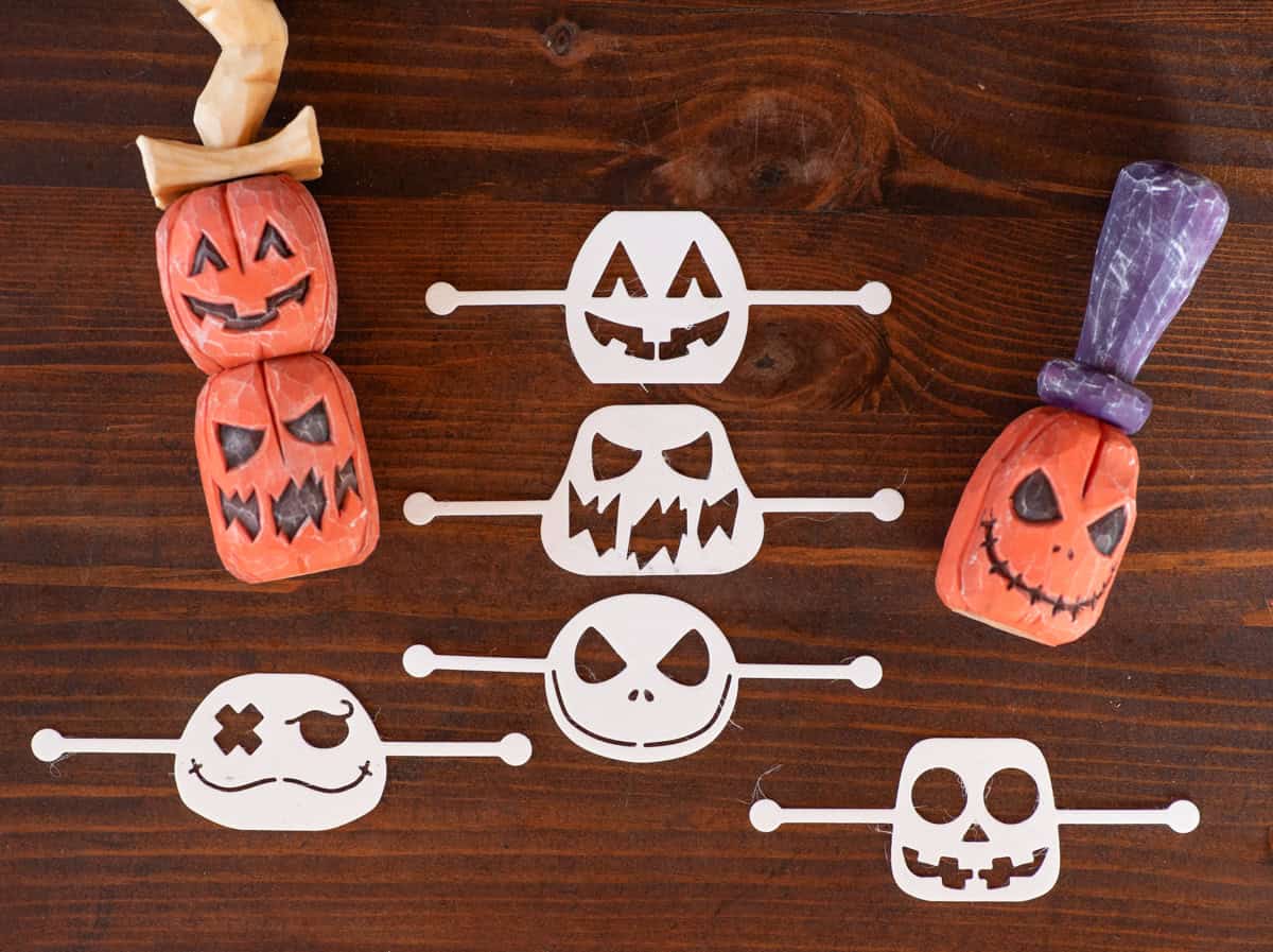 five stencils for laying out a wood jack o lantern face and three carved wood pupmkins