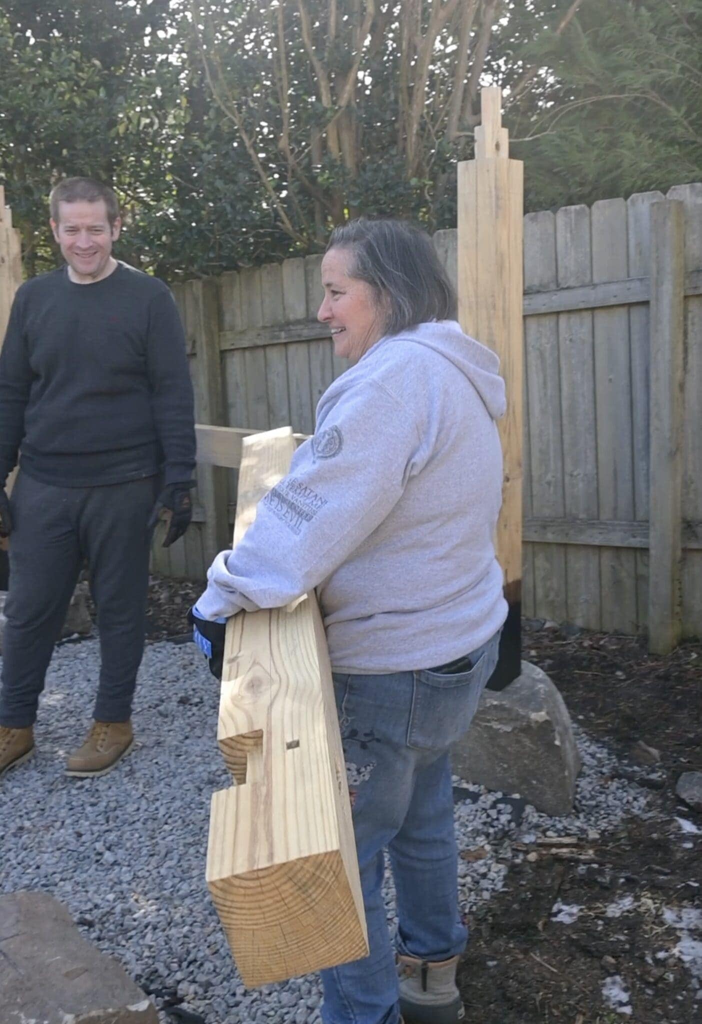 a woman carrying a large timber with joinery
