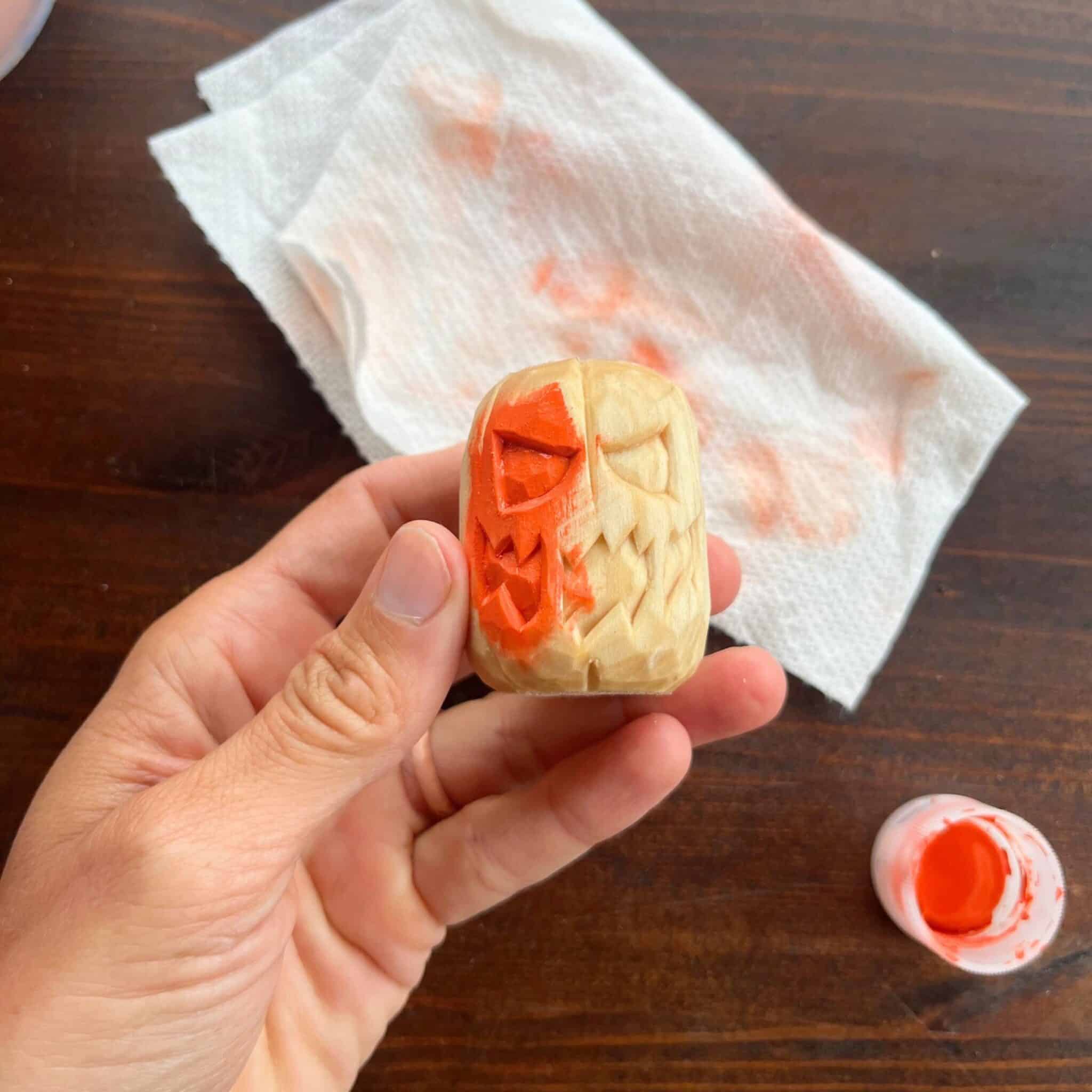 orange paint on a wood carved pumpkin