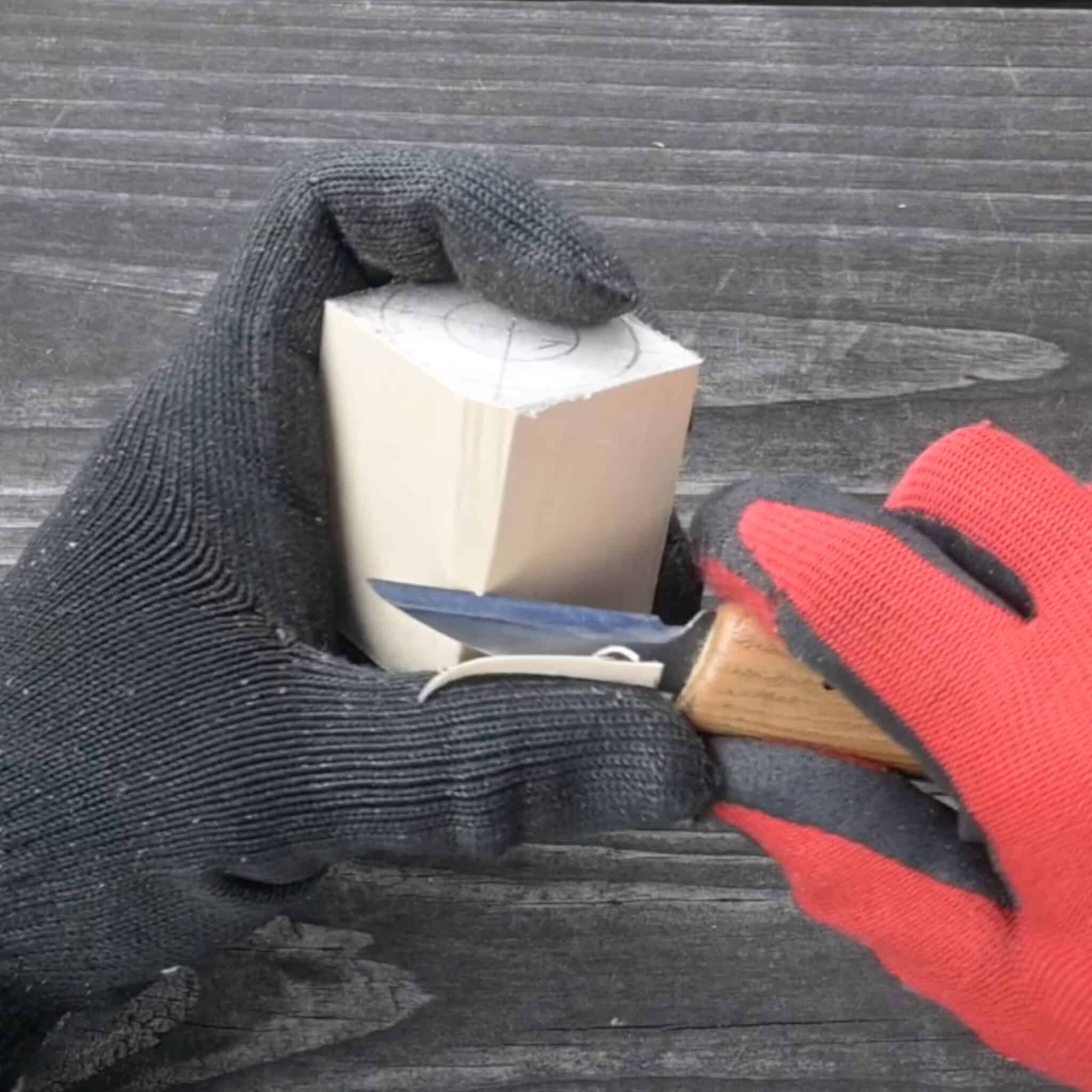 using a roughing knife to cut away at a block of wood
