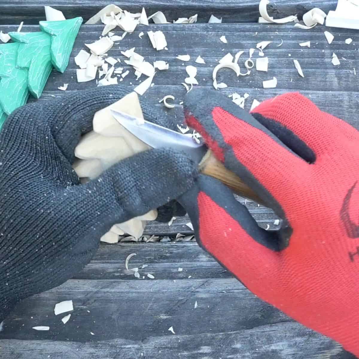 sloping the top of a wood carved christmas tree using a carving knife