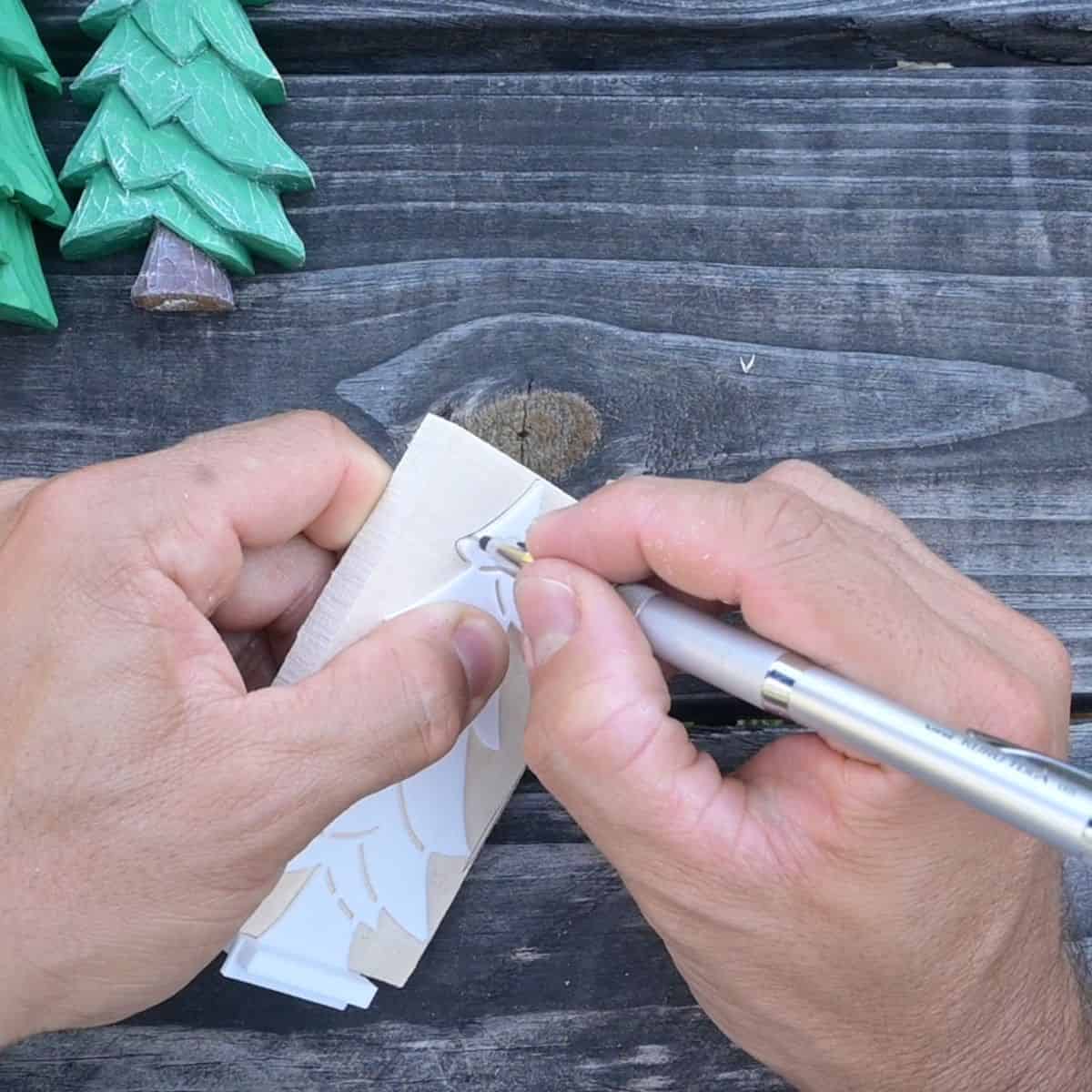 tracing a christmas tree onto wood using a stencil