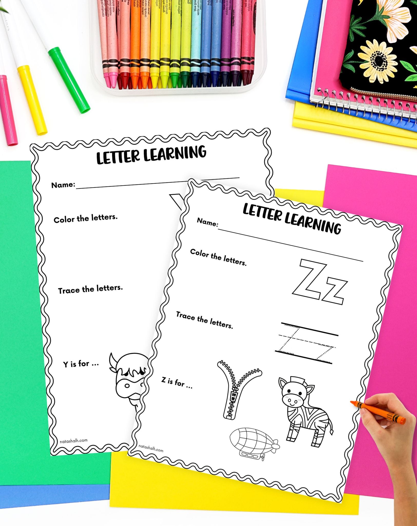 a child's hand preparing to use an alphabet tracing and coloring page showing the letter z