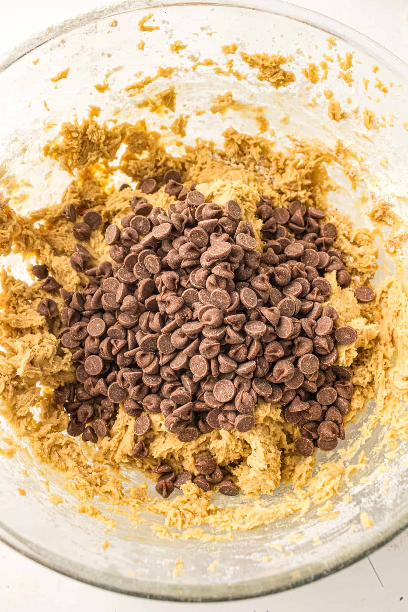 adding chocolate chips to cookie dough
