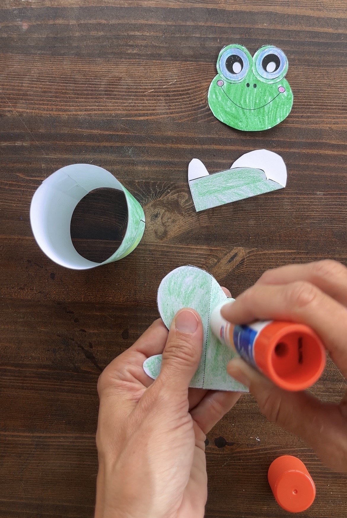putting glue on paper frog legs