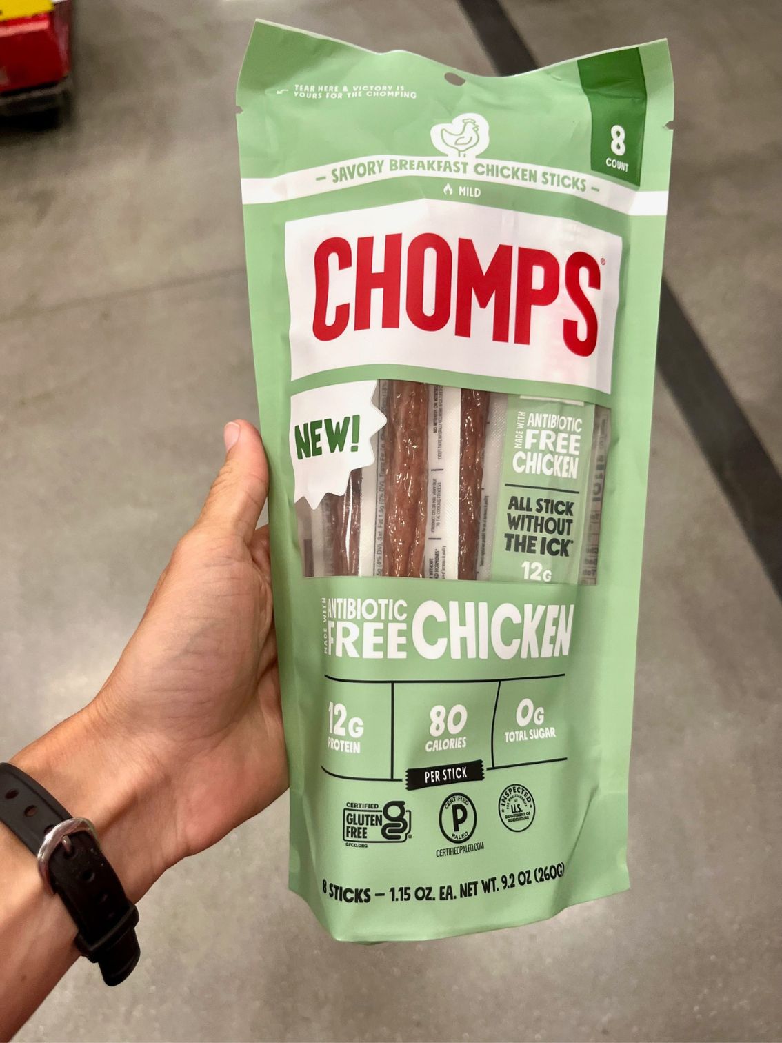 a hand holding a bag of chicken Chomps meat sticks