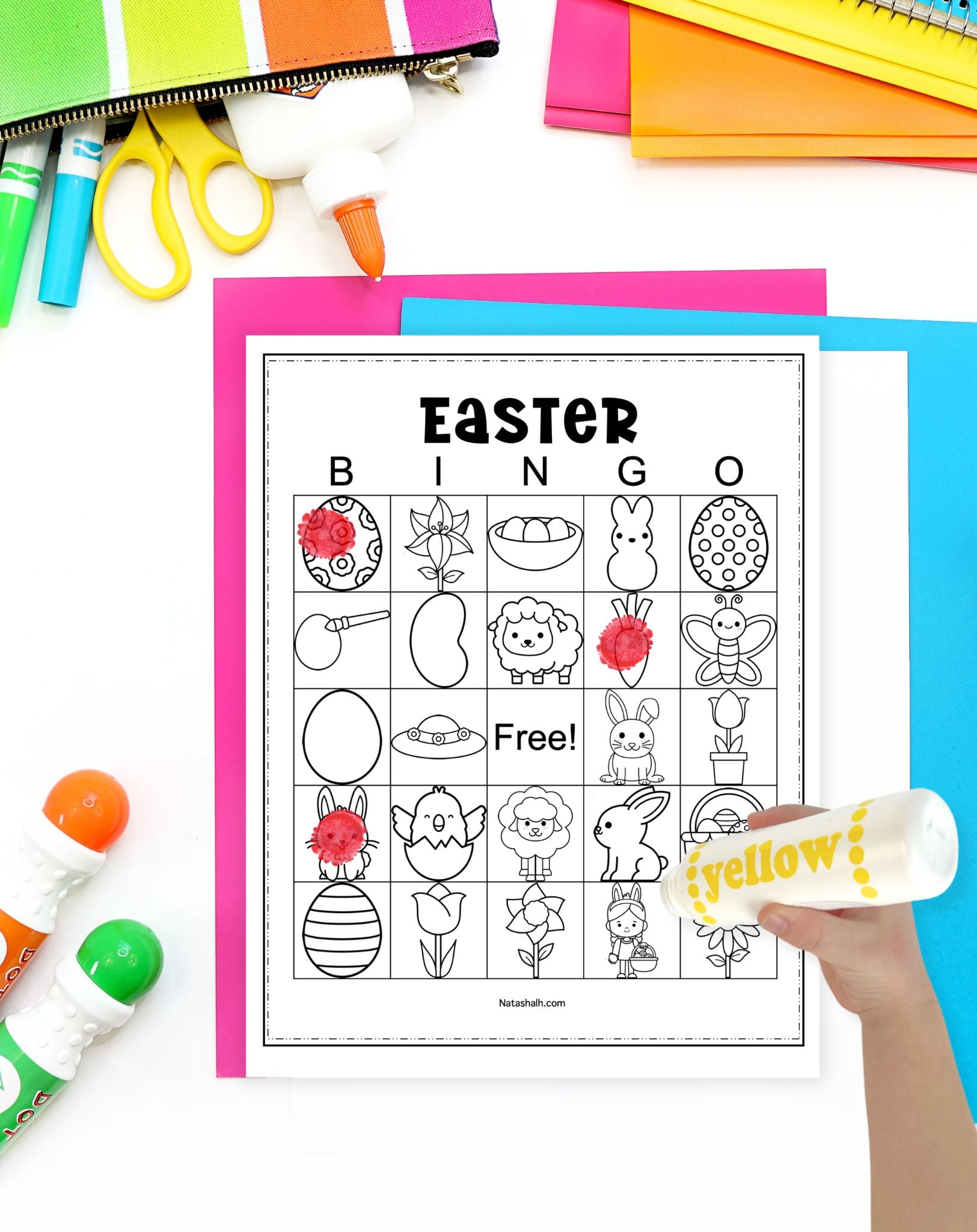 a hand with a dot marker filling in an Easter bingo card