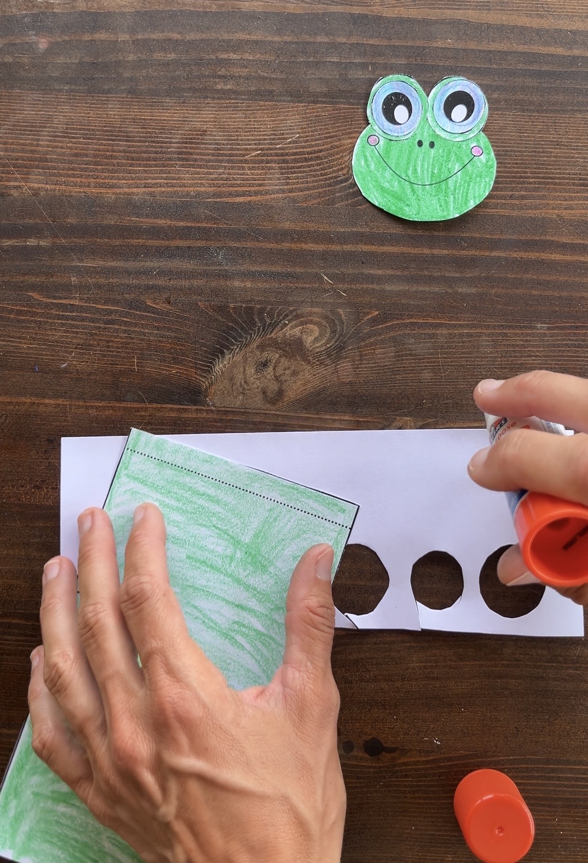 gluing the body of a frog paper craft