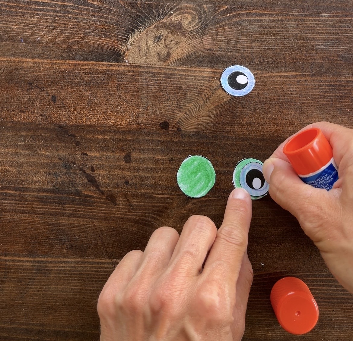 gluing eye pieces to make a frog craft