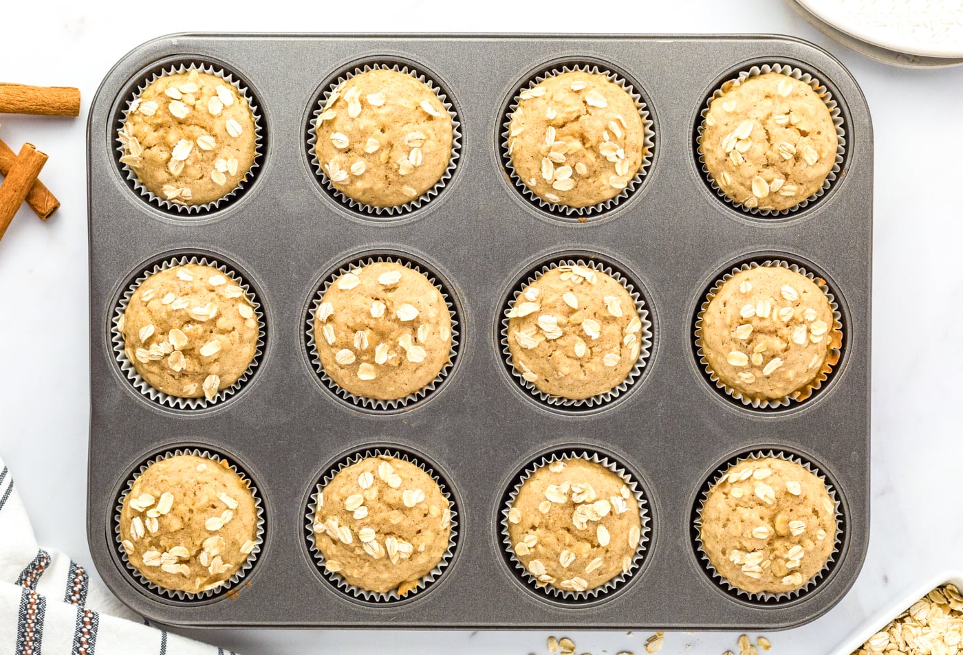 a top down photo of a tray of 12 baked gluten free oatmeal muffins