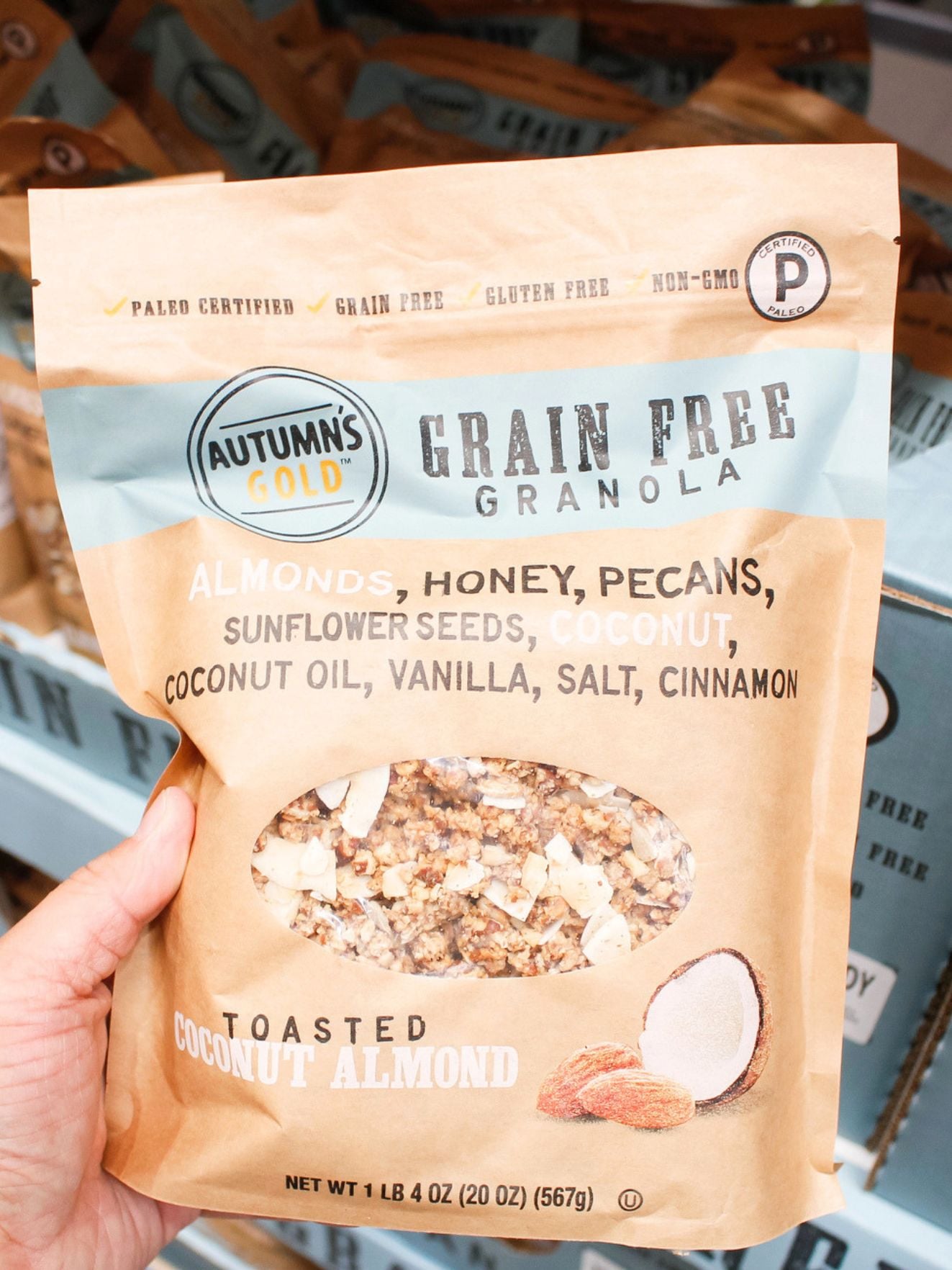 a hand holding a bag of grain free granola