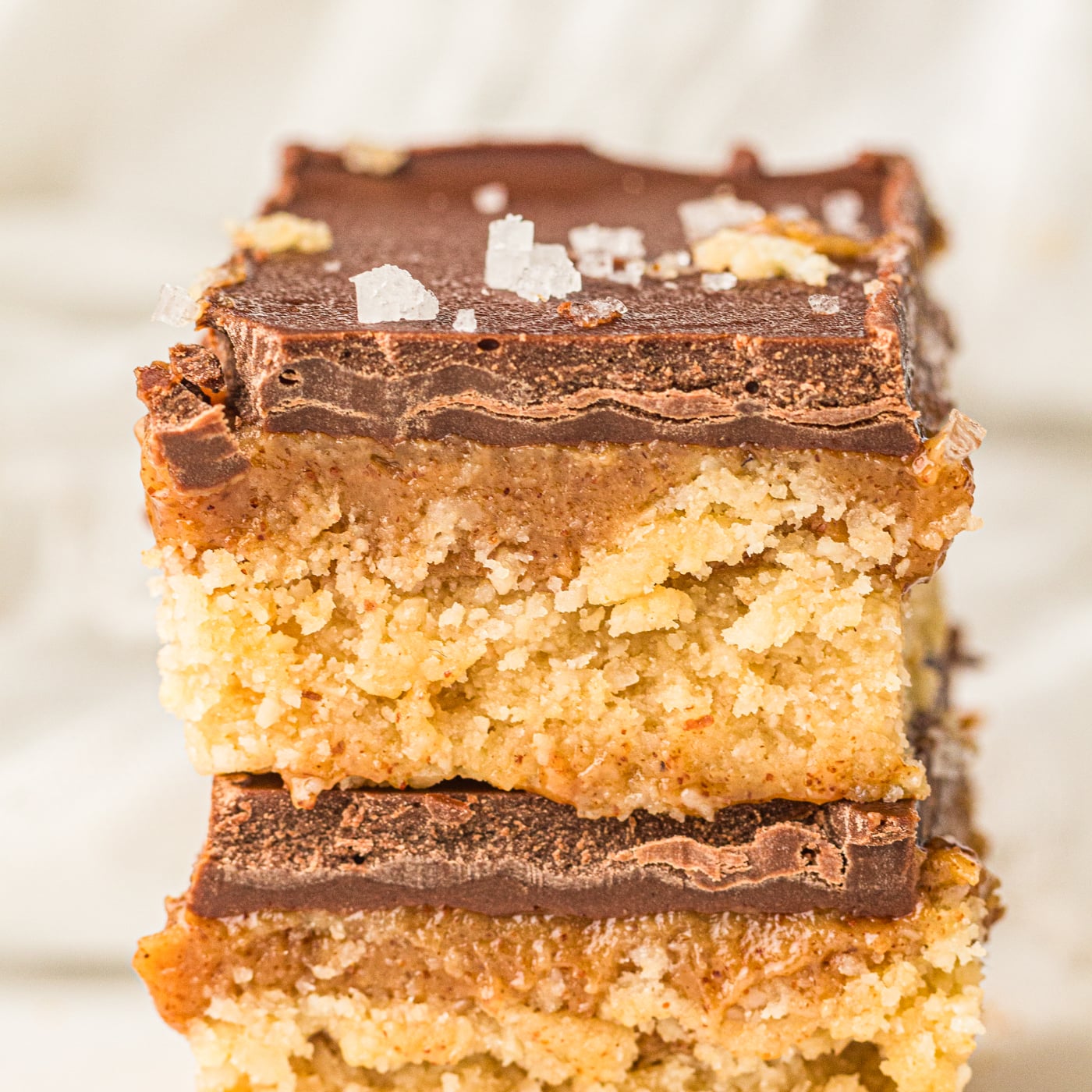 two thick copycat twix bar cookies made with almond flour and maple syrup