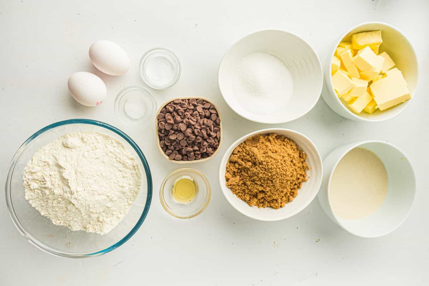 ingredients for a bakery style sourdough discard chocolate chip cookie on a white counter