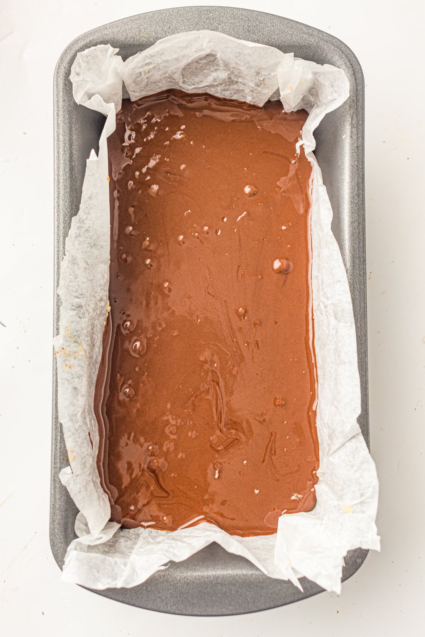 spread chocolate on a pan of gluten free copycat twix bars