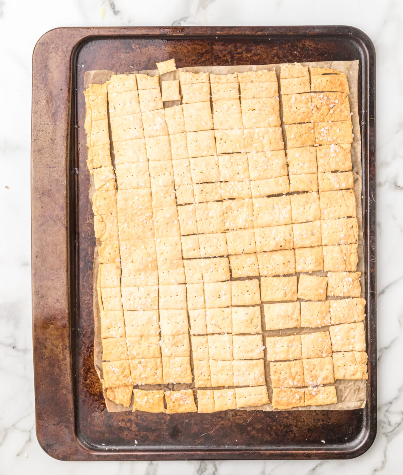 rolled out sourdough discard cracker dough on a baking sheet after baking