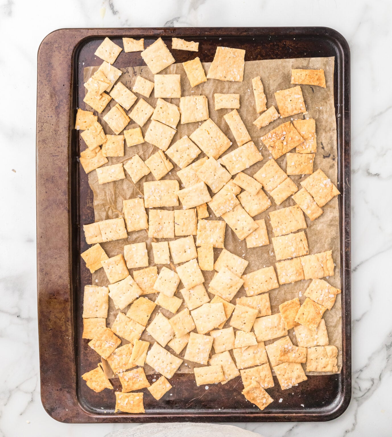 sourdough discard cracker dough on a baking sheet after cooling and snapping