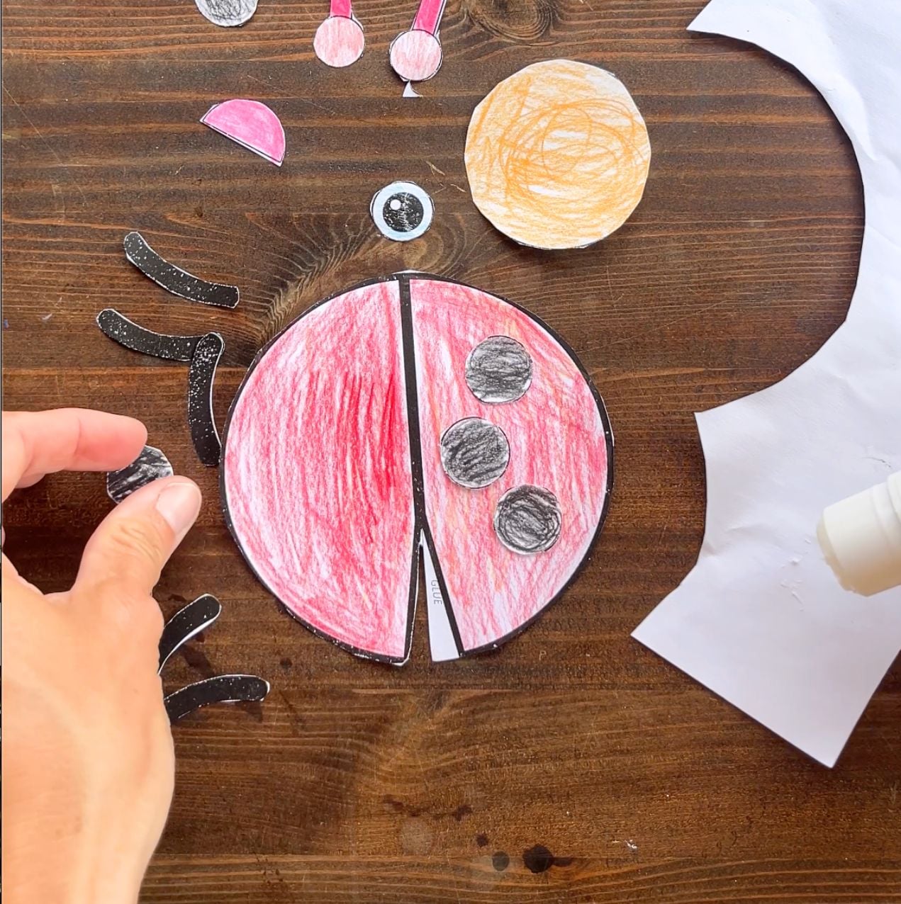 gluing spots on a paper ladybug craft