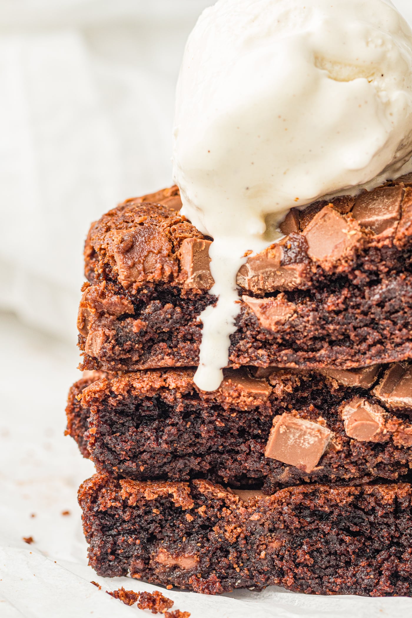 a stack of slices of chocolate dump cake with ice cream on top