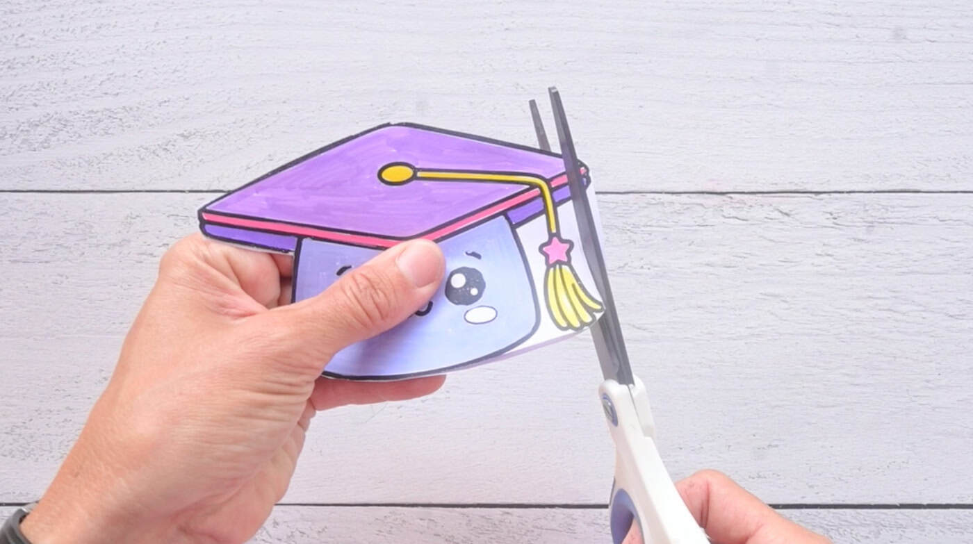 cutting out paper templates to make a paper squishy graduation cap