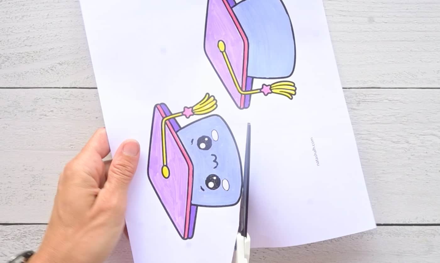 cutting out paper templates to make a paper squishy graduation cap