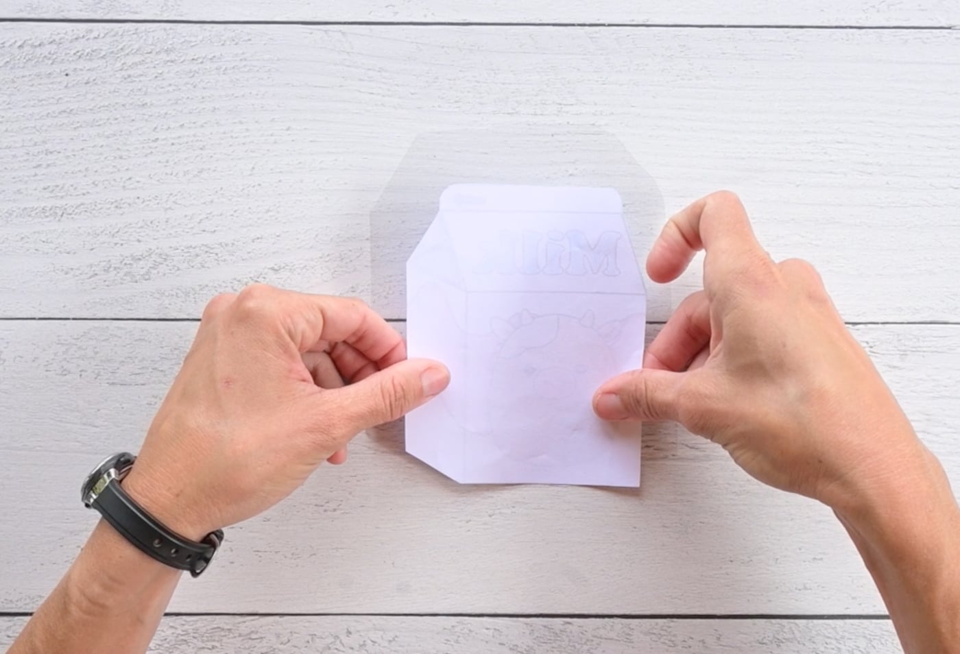 placing a milk carton template face down on clear contact paper