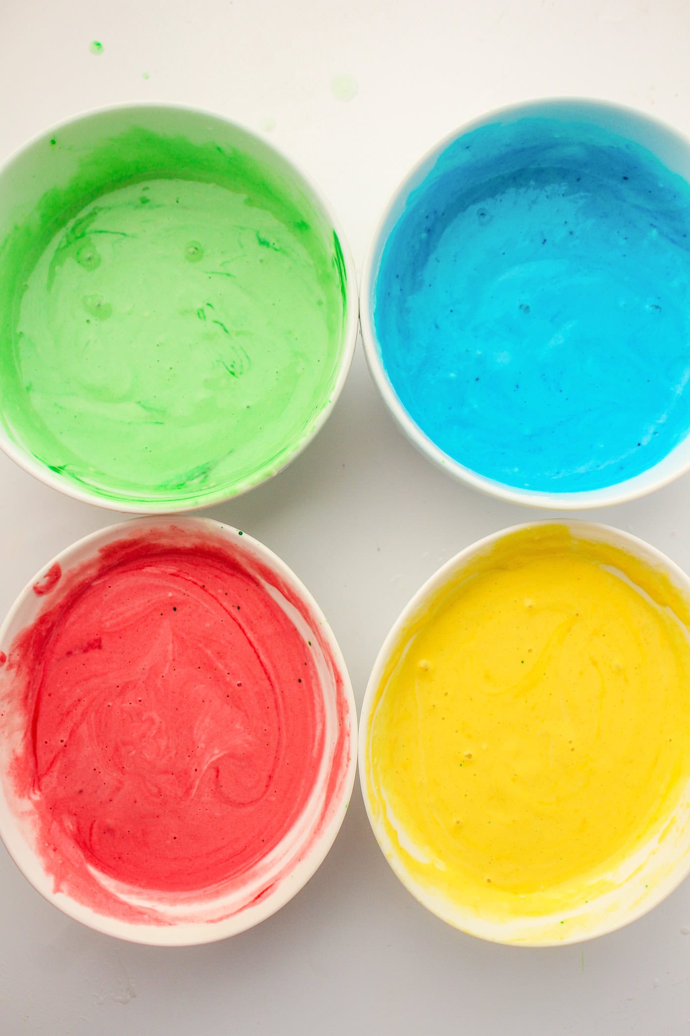 a top down view of four bowls of homemade puffy sidewalk paint