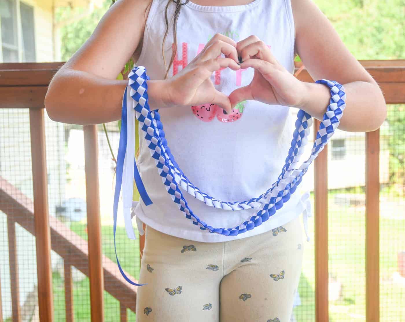 a child holding a ribbon lei