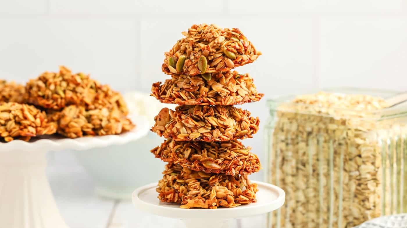 a stack of gluten free granola cookies in front of a jar of oatmeal