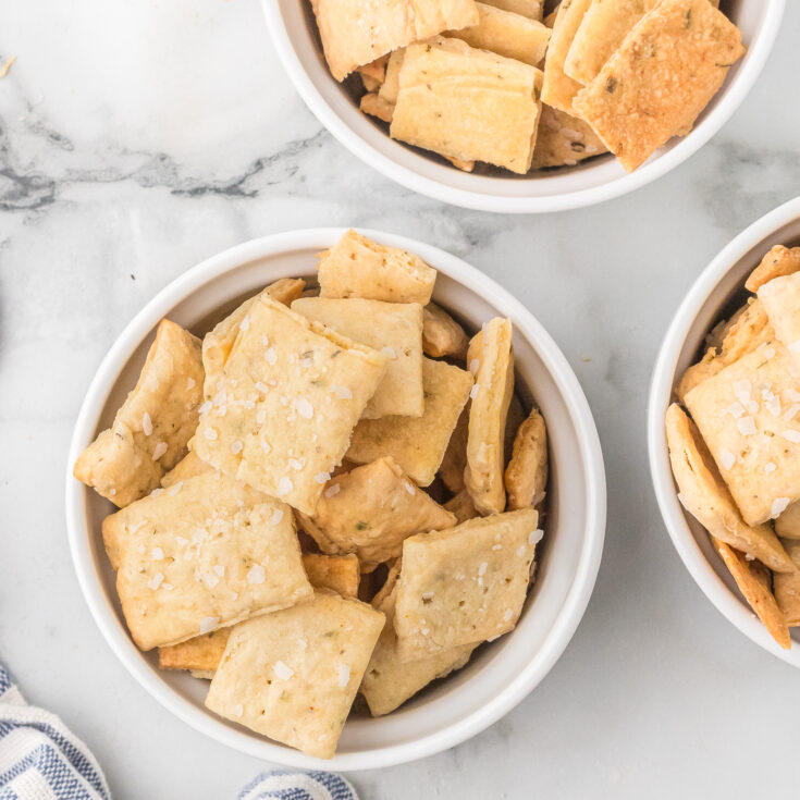 a top down photo of three ramekins of homemade sourdough discard crackers