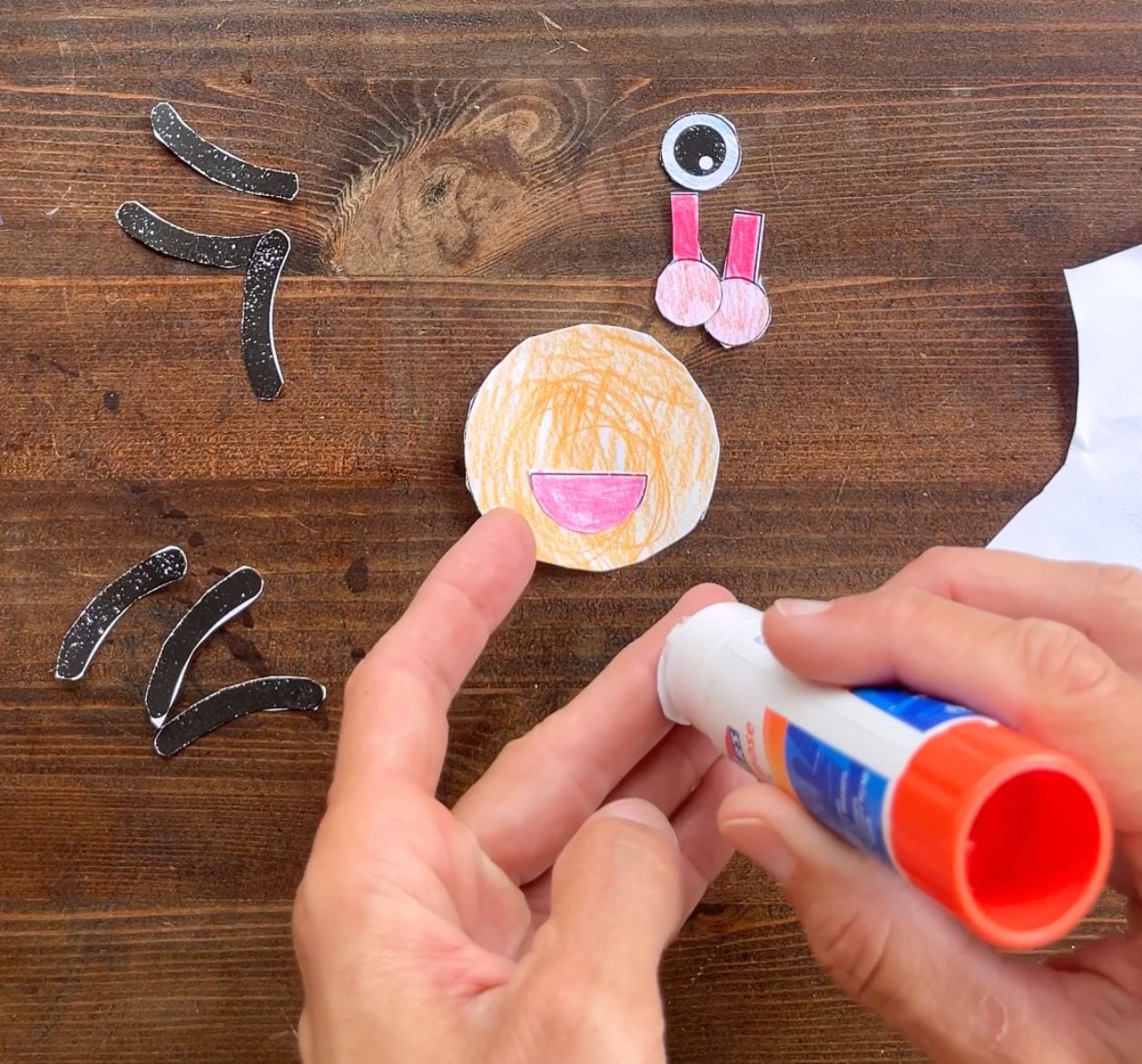 gluing pieces together to make a paper ladybug craft face