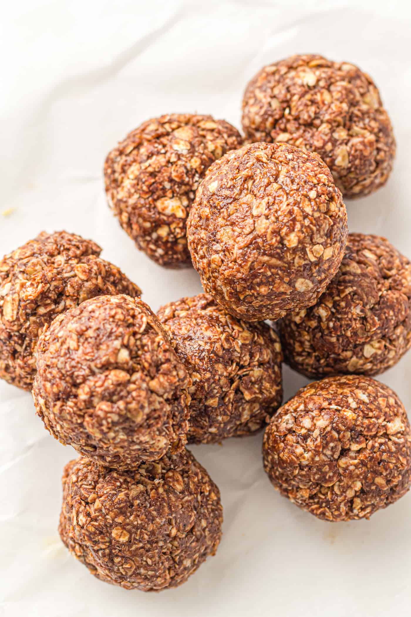 a close up view of about a dozen no bake energy balls with peanut butter and oatmeal