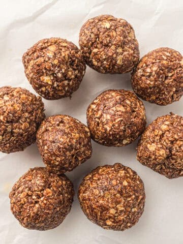 a stack of no bake peanut butter oatmeal energy balls on a piece of parchment paper