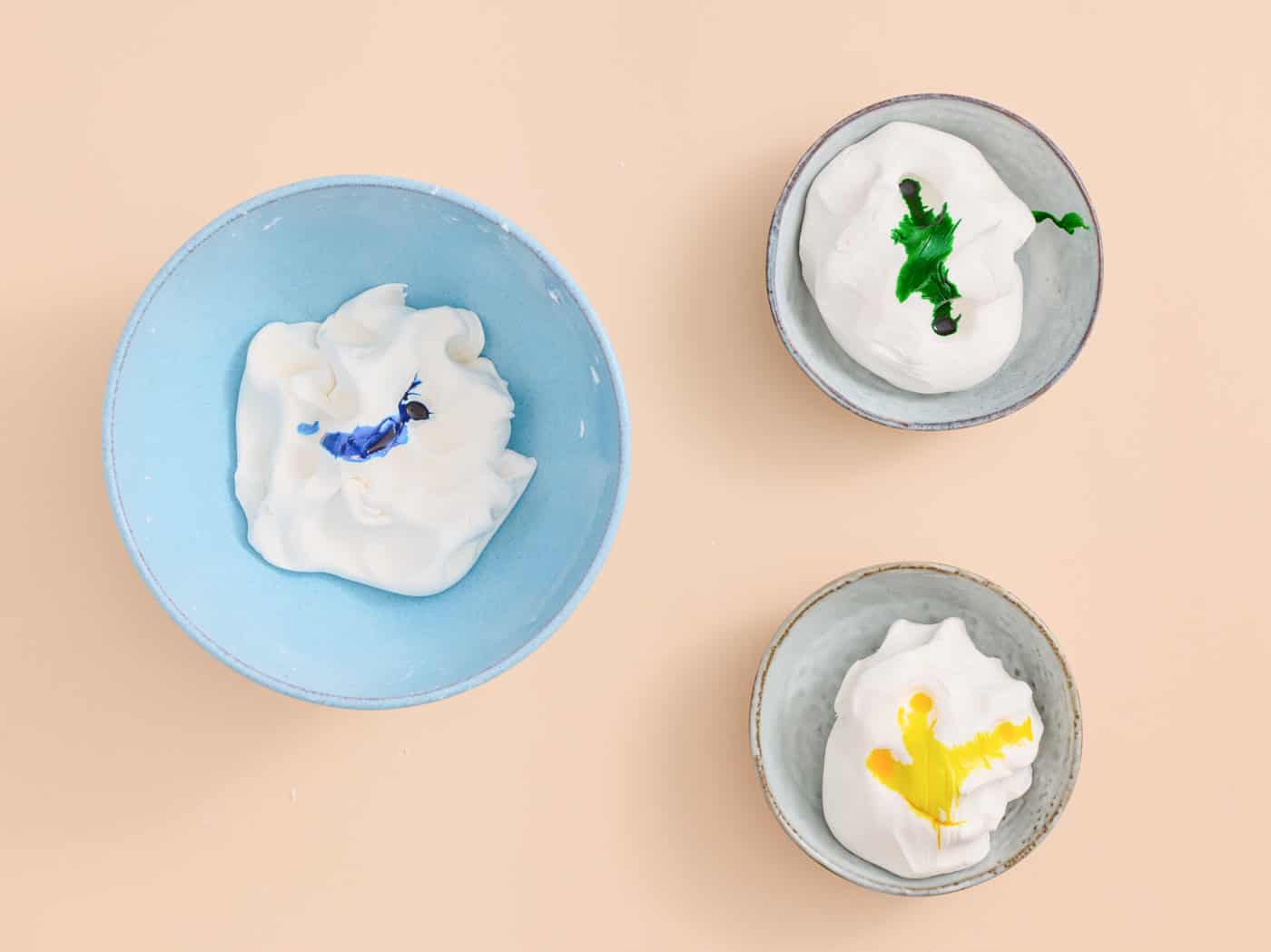 adding color to three bowls of homemade cloud dough