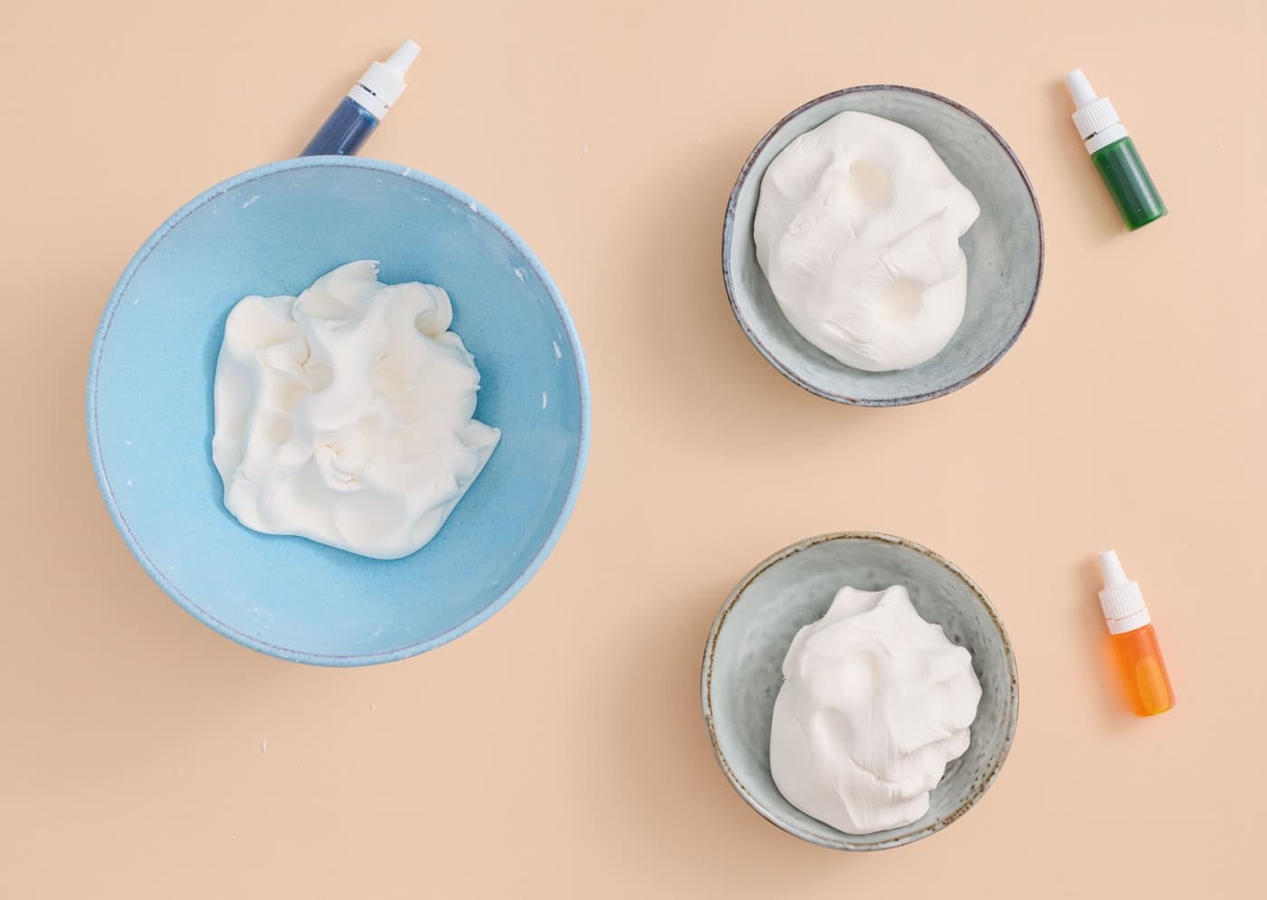 homemade cloud dough separated into three bowls for adding color