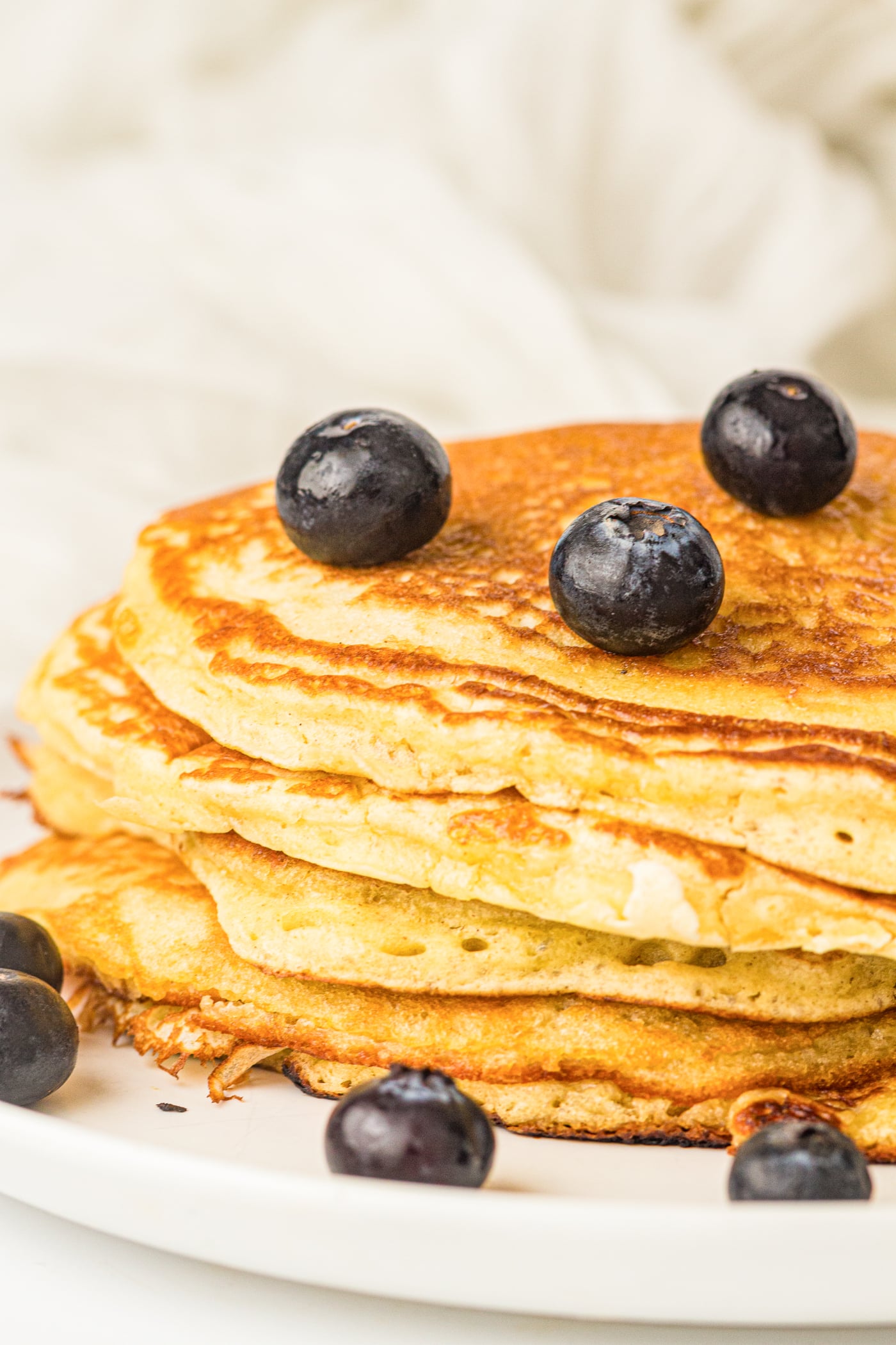 a stack of sourdough discard pancakes with blueberries on top
