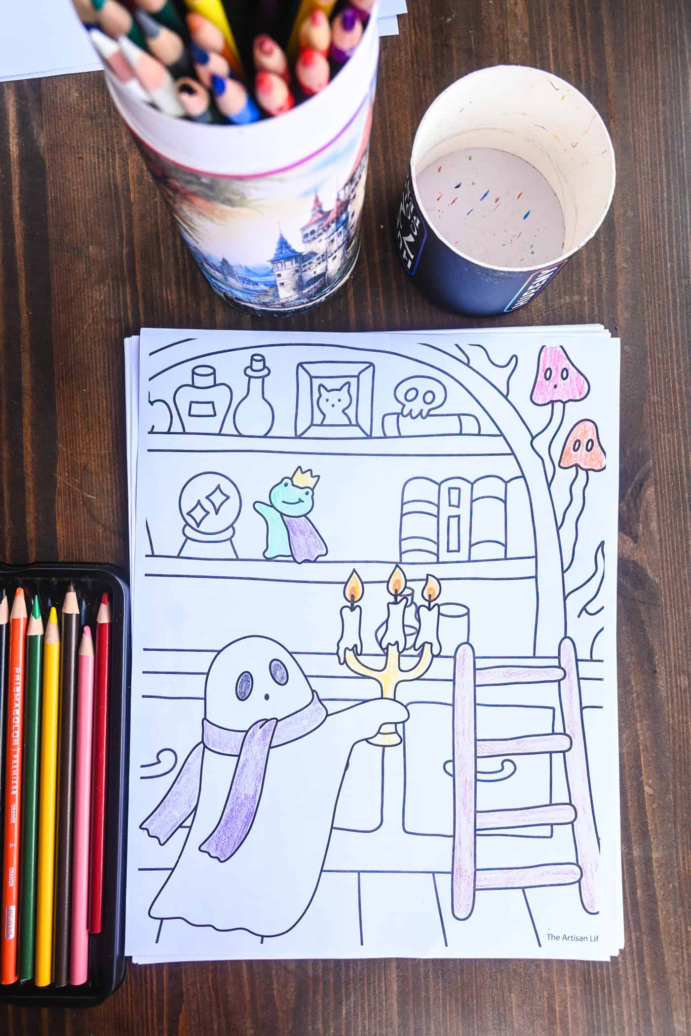 a top down photo of a spooky cute coloring page of a ghost in a library shown alongside colored pencils