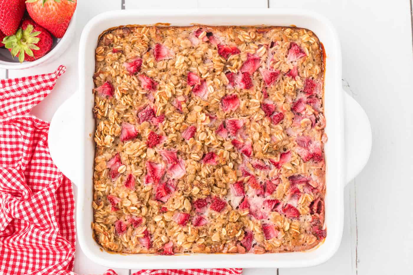 a top down photo of a baked 8x8 pan with strawberry baked oatmeal