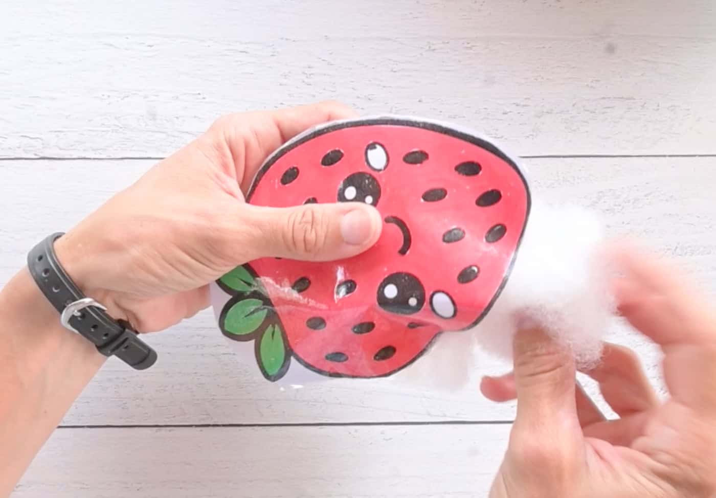 adding stuffing to a paper strawberry squishy