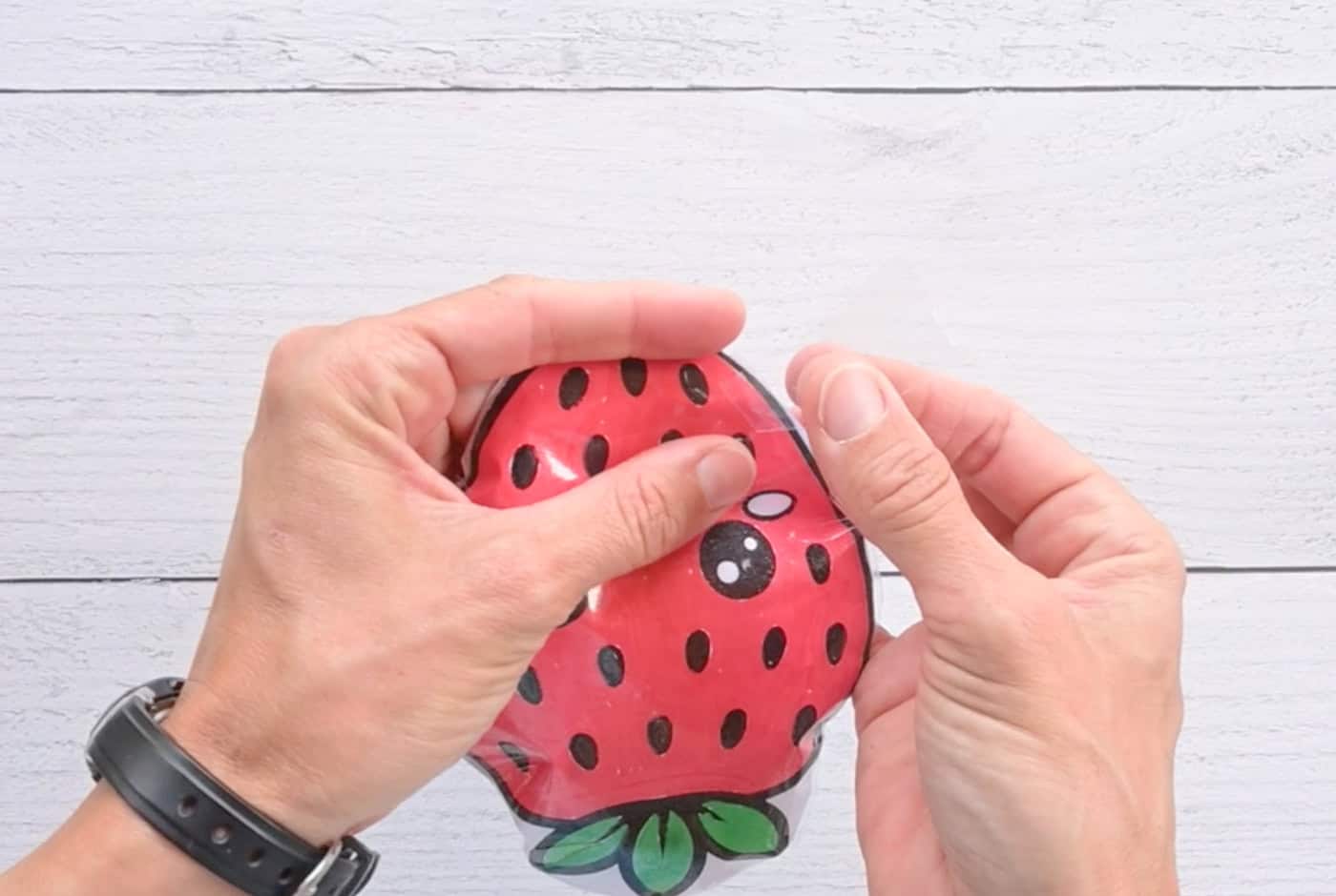 taping a paper strawberry squishy closed