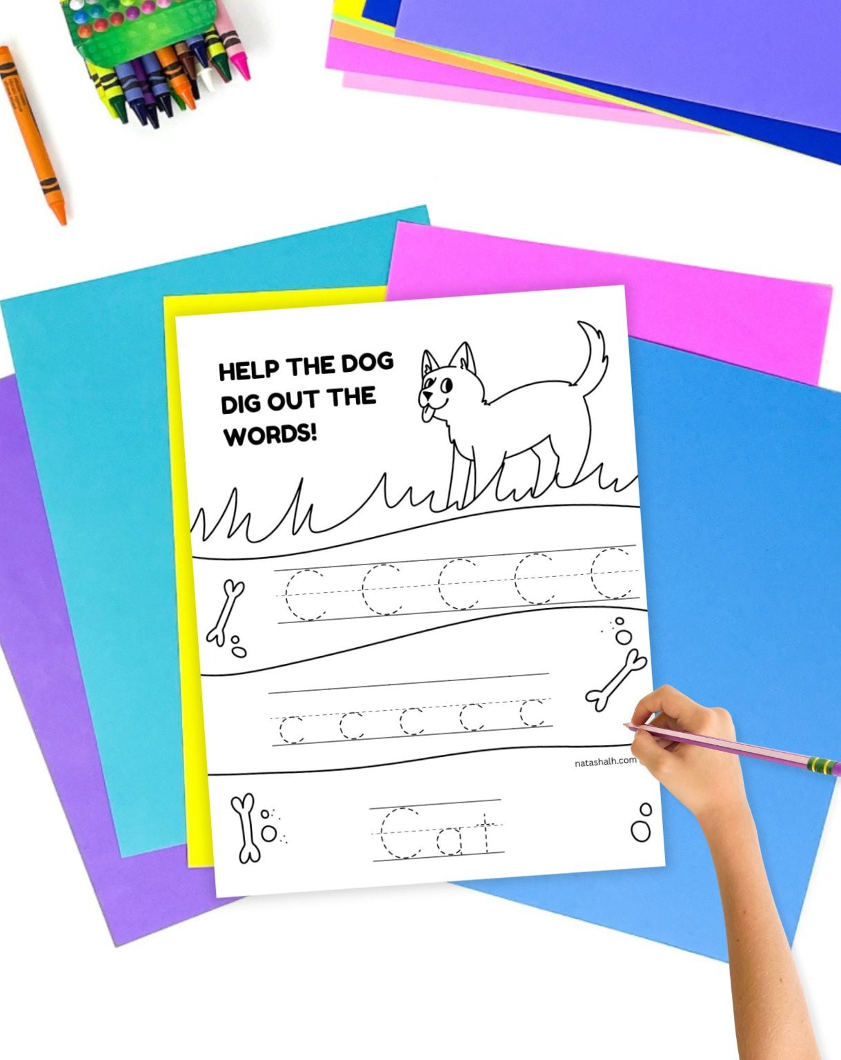 a child's hand holding a pencil and preparing to use a letter c tracing page