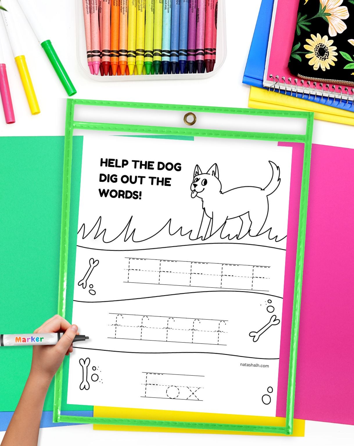 a child's hadn't with a marker preparing to use a handwriting practice page in a dry erase pocket