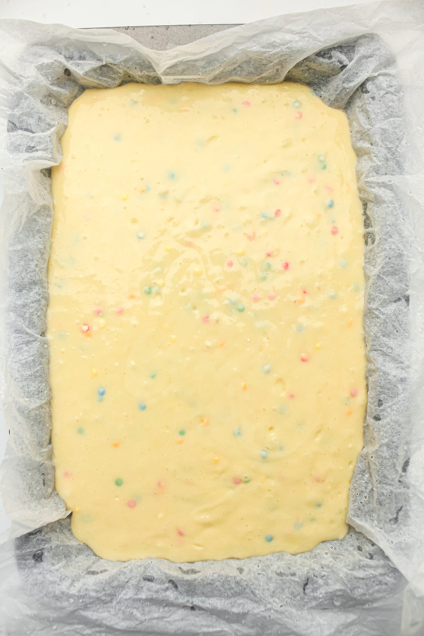 batter for a gluten free DIY funfetti cake in a pan