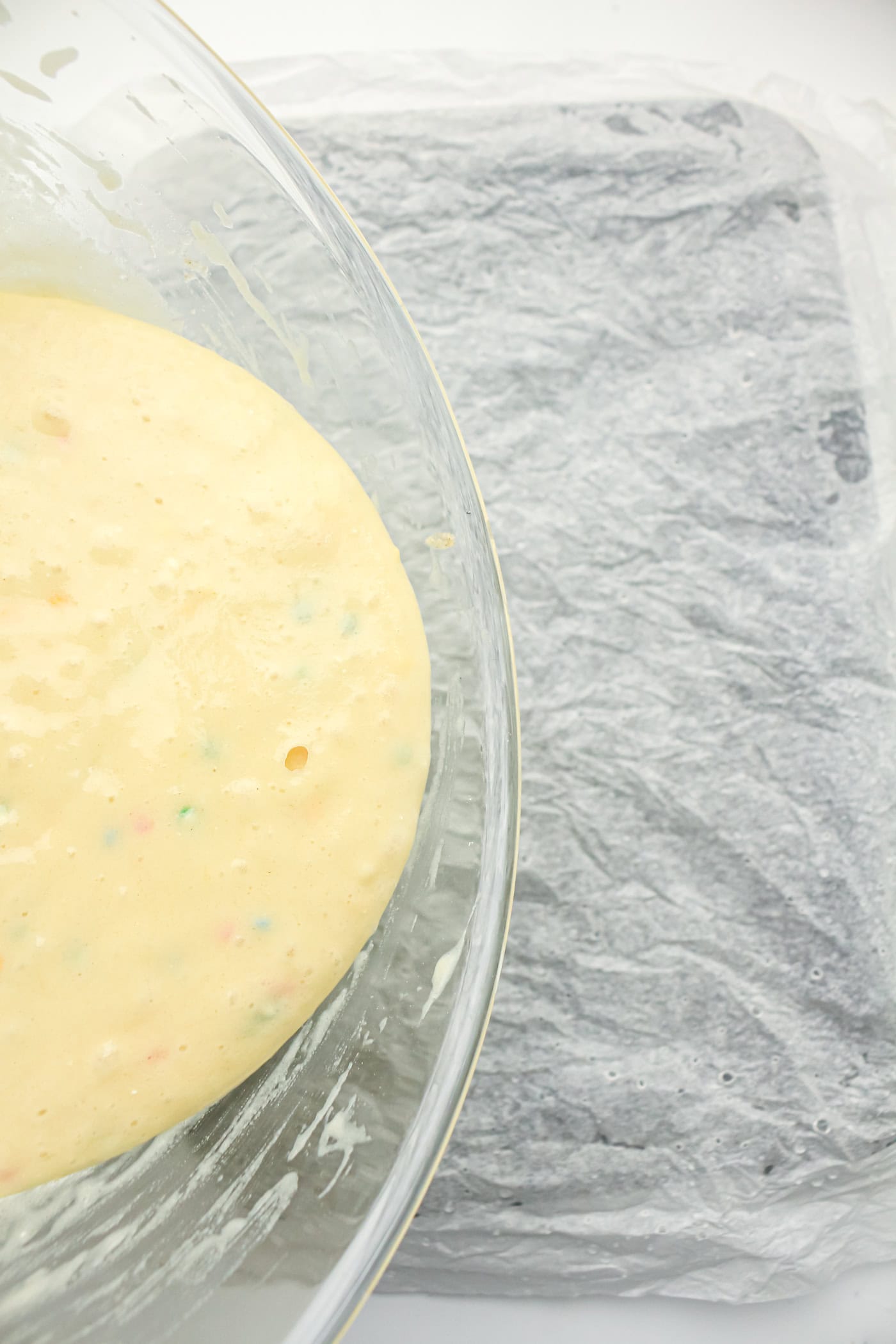 pouring batter for a gluten free DIY funfetti cake in a pan