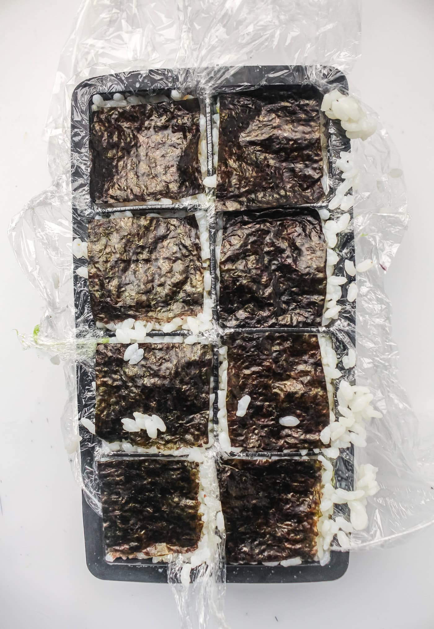 seaweed on each pocket of an ice cube tray for ice cube tray sushi salmon rolls