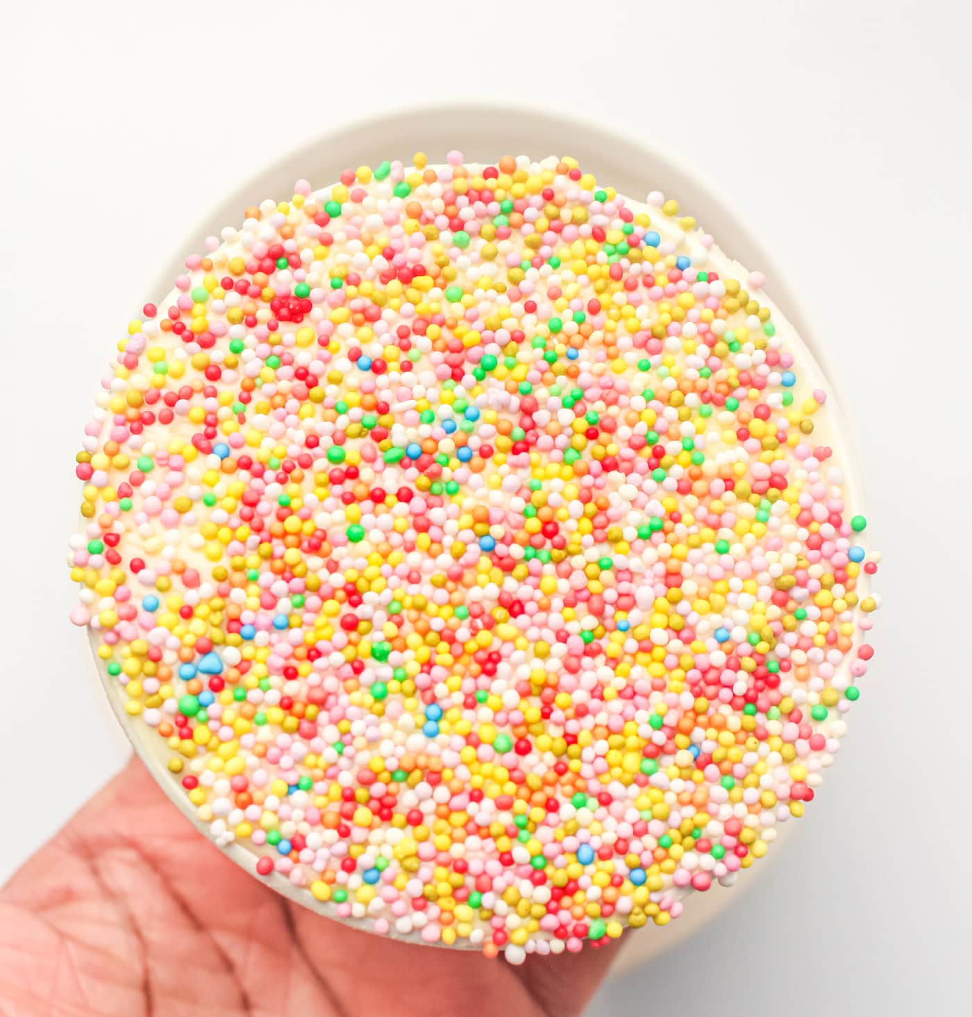 a hand holding a gluten free dot cake