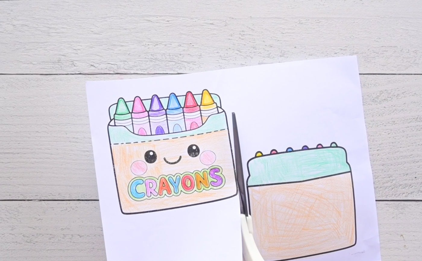 cutting out the pieces for a diy paper squishy that shows a kawaii box of crayons